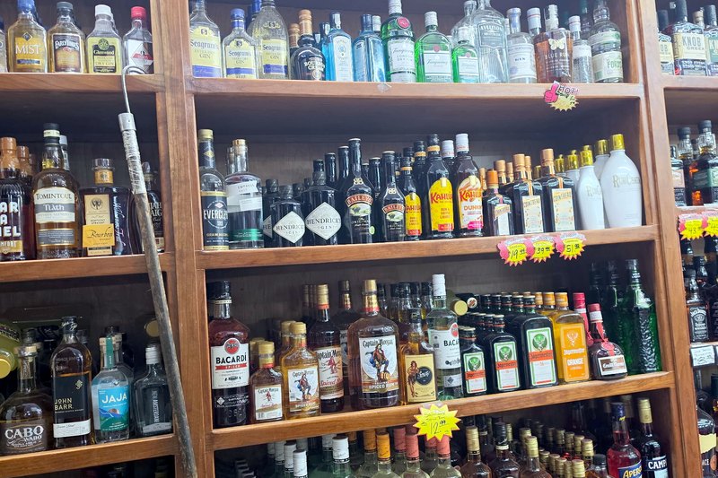 The tequila and rum wall on warm wood shelving